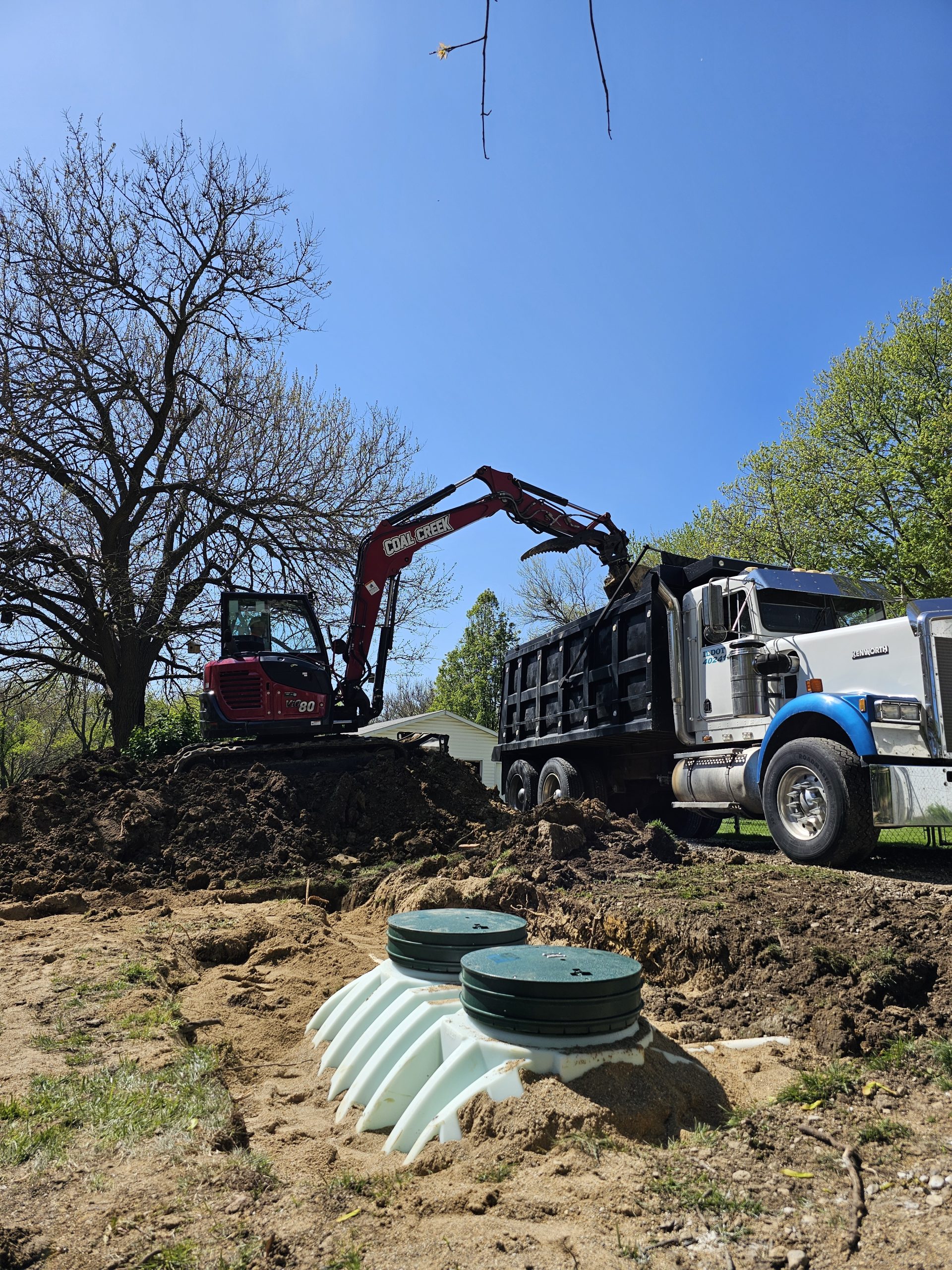 Excavator unloads dirt into a dump truck