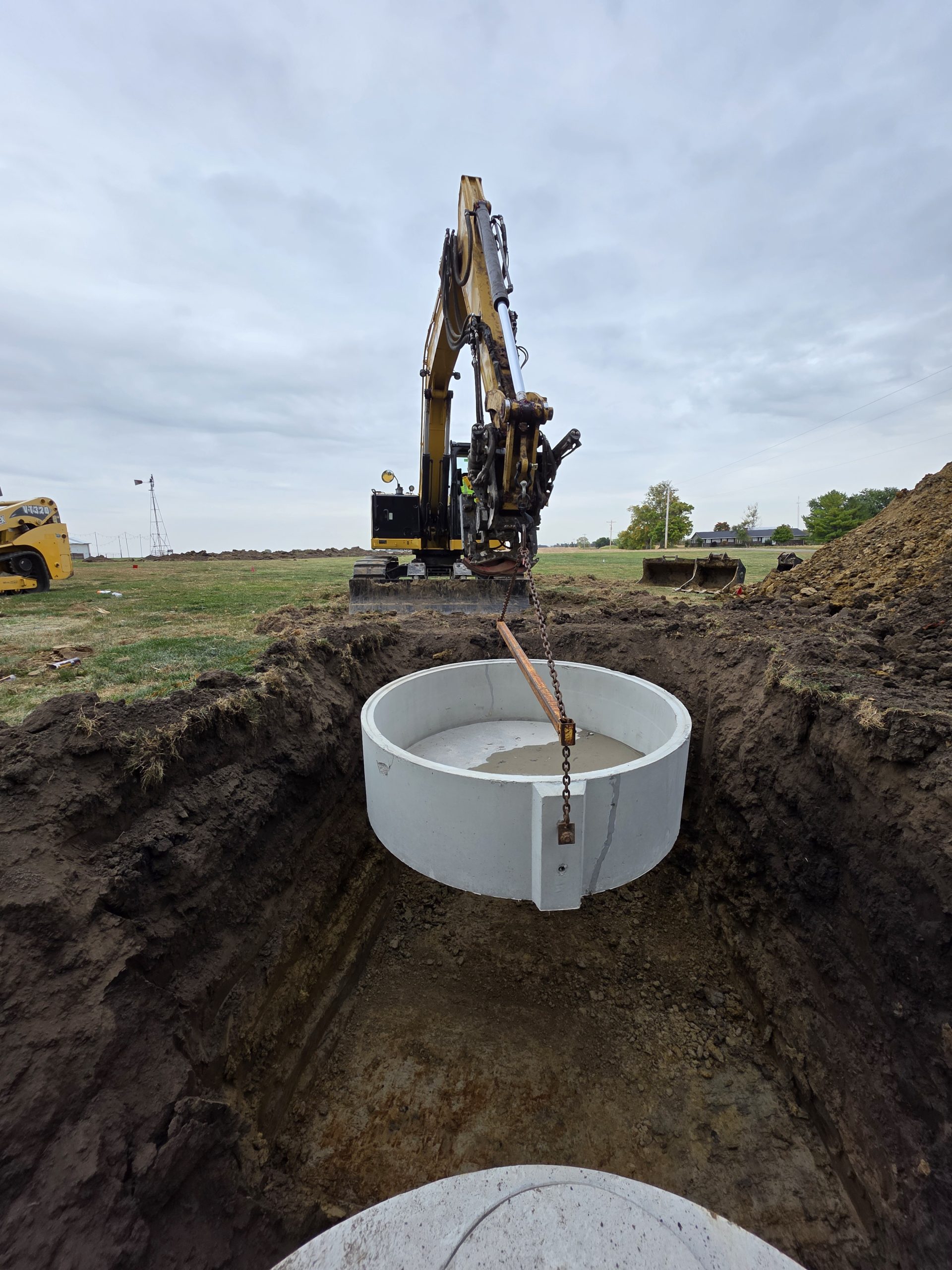 Septic tank sits in a deep, grassy trench